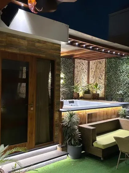 We created this private oasis by integrating a jacuzzi deck seamlessly into the terrace garden. The space features a cozy seating area, lush vertical green walls, and carefully placed lighting to create a tranquil atmosphere for relaxation. An adjoining room provides a space to unwind after a dip.