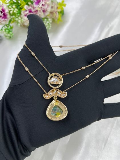 The Myra Crystal Bloom Necklace. This is another lightweight, double-chain design with crystal pendants, perfect for modern and minimalist tastes. Available in red and green.