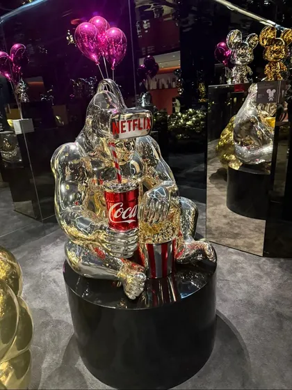 A silver gorilla sculpture enjoying Netflix and a Coke. This piece, seen at our Hyderabad exhibition, is a perfect example of our humorous and culturally relevant collection.