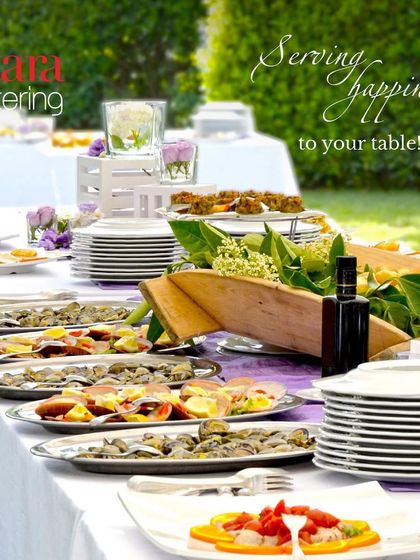 Serving happiness to your table. A beautifully set long table for an outdoor event, showcasing our elegant plating and arrangement for a sit-down meal.