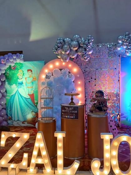 A close-up of the marquee letters and the layered backdrops of the princess party stage.