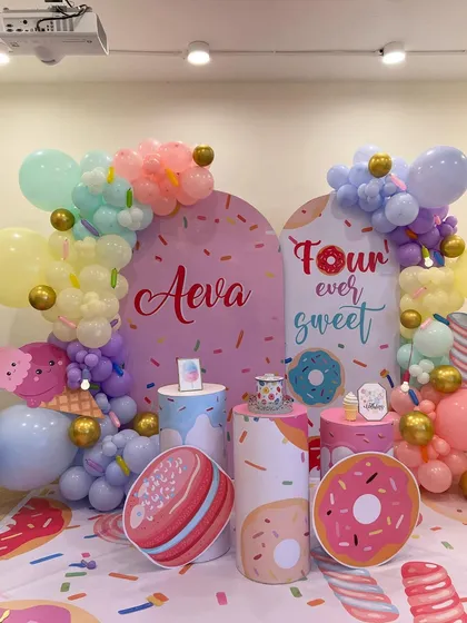 A sweet "Four Ever Sweet" candyland and donut themed birthday party. The decor uses pastel colors, donut cutouts, and custom backdrops to create a delicious-looking celebration for a 4th birthday.