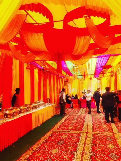 A view of the buffet line and guest area inside the spacious tent, showcasing a complete setup for a large gathering.