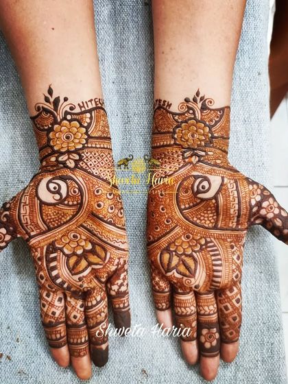 A traditional henna design featuring a unique yin-yang style peacock motif on the palms. This is a beautiful and balanced design, perfect for any member of the wedding party.