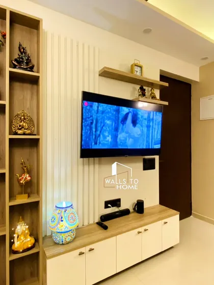 This TV unit combines a light wood console with a vertical display shelf and a textured back panel. It’s a simple, elegant, and functional design for a modern living room.