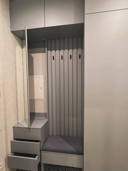 A close-up of the foyer unit, showing the pull-out drawers for storing keys and small items. The design cleverly conceals a fuse box behind a mirrored panel, maintaining a clean look.