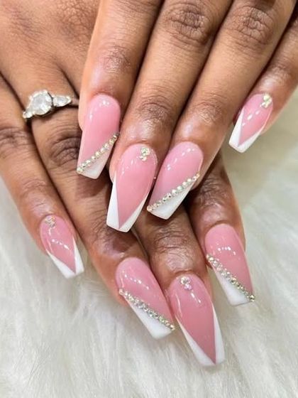 A glamorous pink and white set with a diagonal French tip design, accented with a line of sparkling rhinestones.