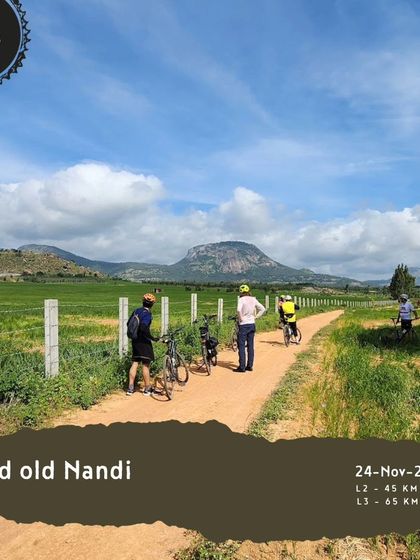 The 'Good old Nandi' tour is a classic for a reason. This image shows riders on a trail through green fields with the iconic Nandi Hills in the background.