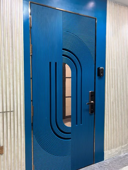 A statement main door with a bold blue PU finish and intricate fluted detailing. This custom safety door combines modern artistry with robust security, creating an unforgettable first impression for your home.