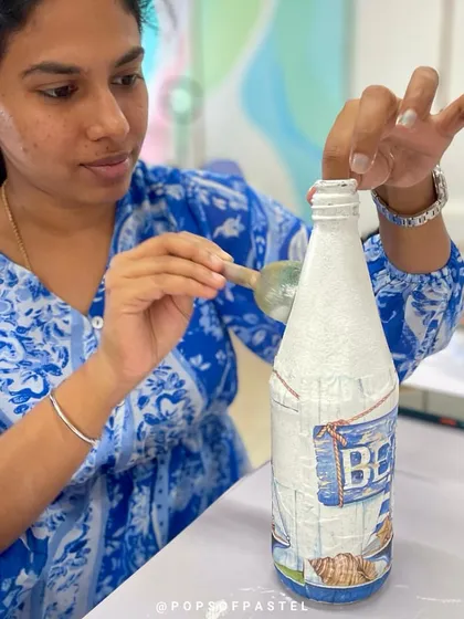 A mom helps her son with a decoupage project, a great craft for upcycling and creating together.