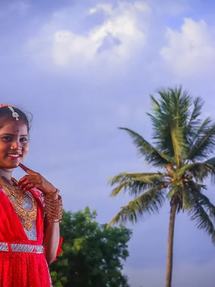 A creative portrait with a dramatic sky. The wide angle and the position of the sun and palm tree create a cinematic feel for this puberty ceremony photograph.