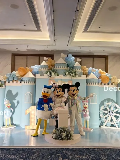 The stage comes alive with mascot appearances! Mickey, Minnie, and Donald Duck pose for photos, adding an interactive and memorable element to the party.