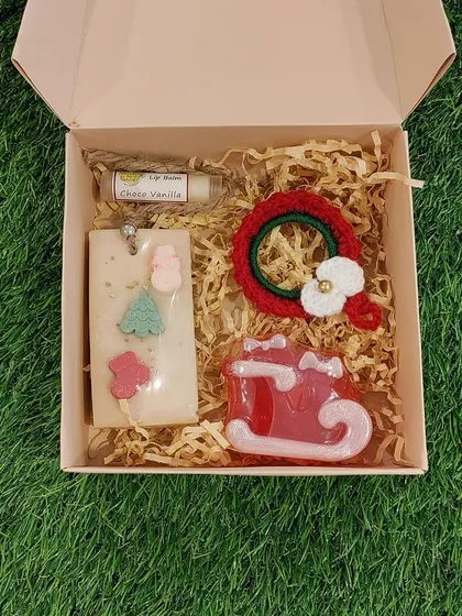 Another view of a beautifully packed Christmas gift box, showcasing a crochet wreath and other curated goodies, ready to be sent to a loved one.