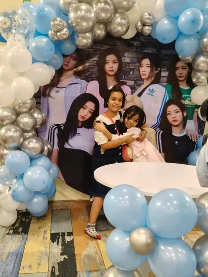 Friends hugging in front of a K-Pop themed backdrop. Parties are all about celebrating with the people you love.