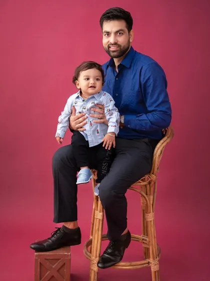 A classic father and son portrait. The simple composition and bold background create a strong and stylish image.