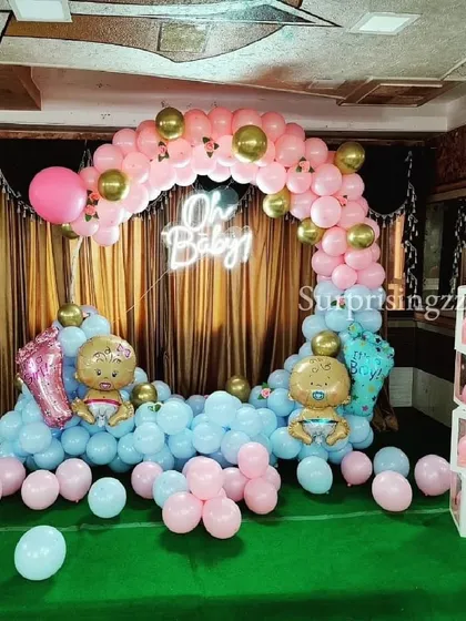 An "Oh Baby" themed baby shower with a pink and blue balloon ring, suggesting a gender reveal or a party for twins.