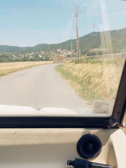 A view from the road, driving through the countryside of Provence. This first-person perspective shot immerses the viewer in the experience of a European road trip.