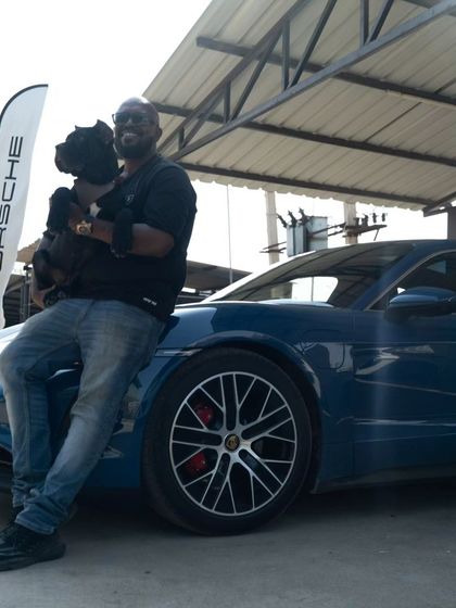Holding my dog while leaning on a Porsche. This collaboration was a unique experience, bringing together man's best friend and man's best machine.