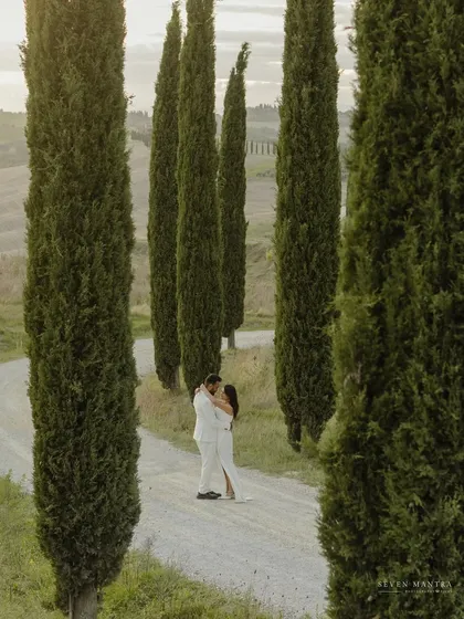 A kiss shared on a winding road lined with cypress trees in Tuscany. This is the kind of iconic, romantic pre-wedding photograph we aim to create during our international couple shoots.