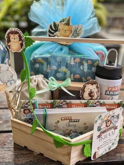 A jungle-themed hamper for a little one's birthday. I used a wooden crate and adorned it with felt leaves, animal cutouts, and a custom-printed card to create a playful safari adventure.