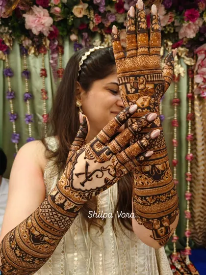 Here is the beautiful result of dedicated learning and application. This is a full bridal design on a happy client, showcasing a combination of personalized initials, traditional motifs, and heavy filler work that you will learn to master.