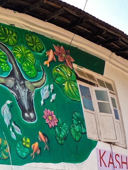 The upper portion of the Fort Kochi mural, showing a buffalo and fish in a pond. This part of the mural represents the rich ecosystem and the daily life that revolves around the water in this coastal town.