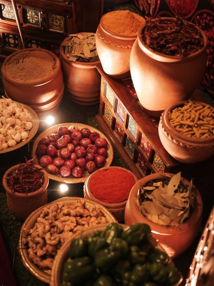 The sensory details of the spice market. Bowls of fresh onions, garlic, walnuts, and colorful powdered spices were arranged to create an authentic and aromatic experience for guests walking through the bazaar.