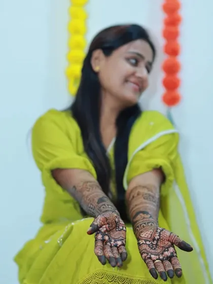 A candid shot of the bride, her smile as bright as her beautiful mehendi.