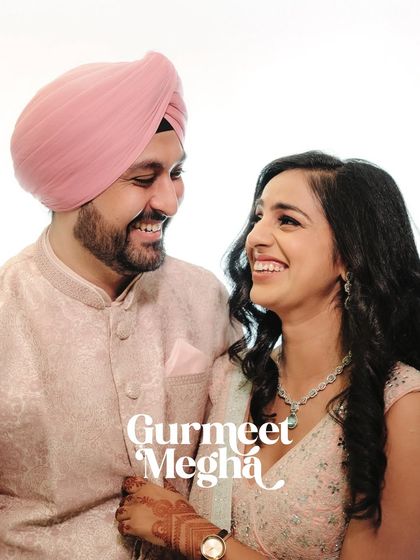 A classic portrait of a smiling couple in traditional pastel outfits. The clean background and happy expressions make for a timeless engagement photo.