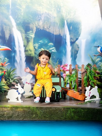 A moment of rest on the jungle safari. This little boy sits on his jeep with his guitar, taking in the sights and sounds of the tropical paradise around him.