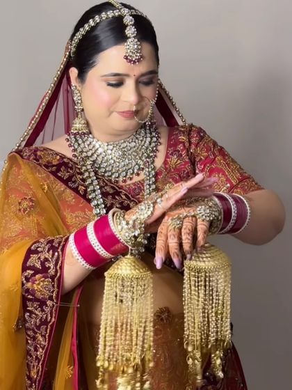 A candid moment of the bride admiring her hands, adorned with mehndi and jewellery.