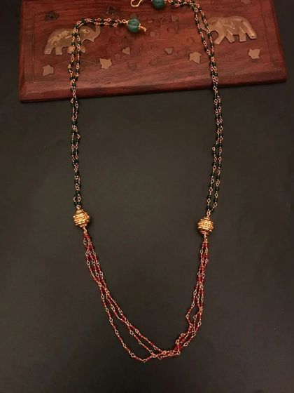 This 92.5 silver gold-plated beaded necklace features a mix of black and red beads with golden accents. It's a stylish and modern piece for daily wear.