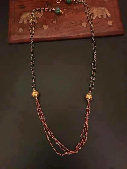 This 92.5 silver gold-plated beaded necklace features a mix of black and red beads with golden accents. It's a stylish and modern piece for daily wear.