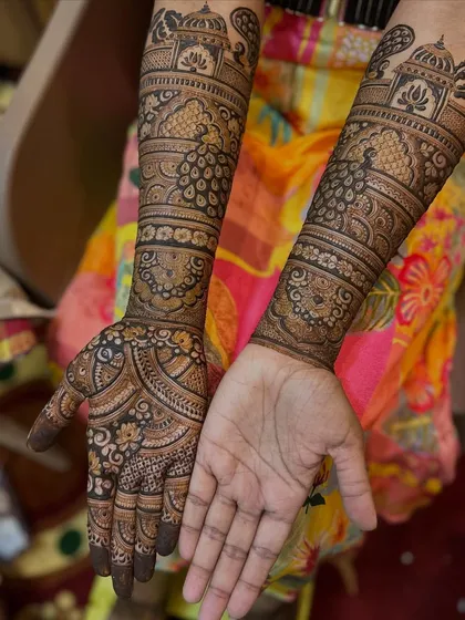 This bridal design showcases beautiful peacocks and architectural domes. The patterns are traditional and elegant, creating a timeless look for the bride.