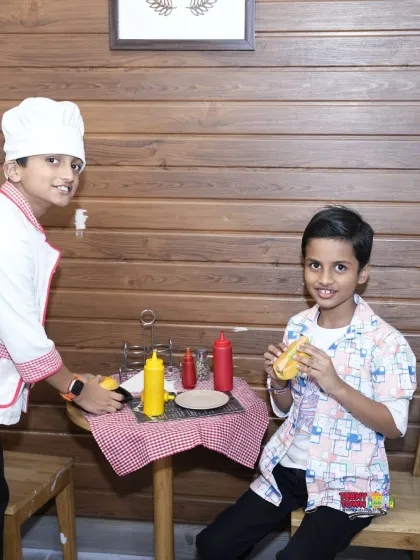 Kids playing together in our pretend-play cafe. These setups encourage social skills and imaginative role-playing.