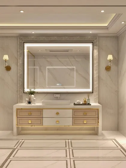 This luxurious bathroom is designed with a palette of cream, taupe, and gold. The space is minimal yet opulent, featuring a large backlit mirror, marble walls, and refined gold fixtures.