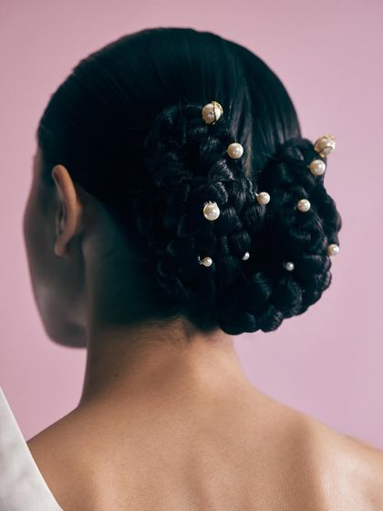 A detail shot of the hairstyle, adorned with pearl-tipped pins. This shows how styling extends to every detail to create a complete and cohesive look.