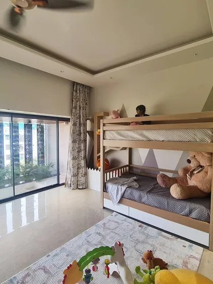 We love designing for our little clients. This children's bedroom features a custom bunk bed with built-in stairs that double as storage, set against a playful mountain-themed wall mural. A large window provides plenty of natural light for play.