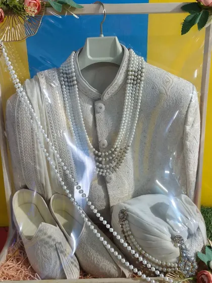 The groom's outfit is just as important. Here, I have carefully packed a sherwani along with the matching jutti and pagdi. The presentation is clean and elegant, ensuring the groom's attire looks sharp for the main event.