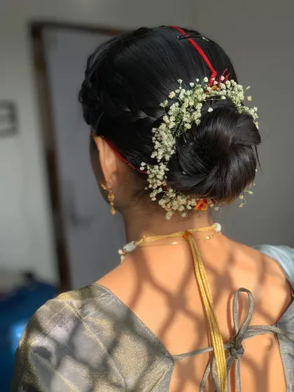 A classic and clean bridal bun adorned with a simple string of baby's breath. This timeless hairstyle is perfect for letting the bride's outfit and jewelry take center stage.