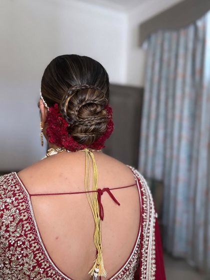 For this bridal bun, I incorporated a braid into the twist for added texture and detail. The deep red cockscomb flowers provide a rich, velvety contrast, making this a truly unique wedding hairstyle.