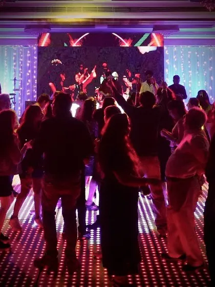 A wide shot of the dance floor during a New Year's Eve event. The illuminated floor and visual projections add another layer to the experience, which I can help arrange.