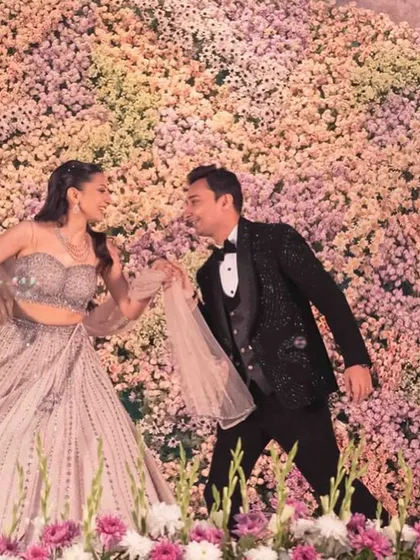 A romantic moment from a couple's dance against a massive wall of flowers. The scale of the decor adds to the grandeur of the performance.