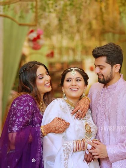 A happy moment between the bride and her siblings, sharing a group hug and a laugh.