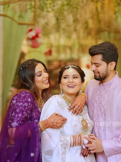 A happy moment between the bride and her siblings, sharing a group hug and a laugh.