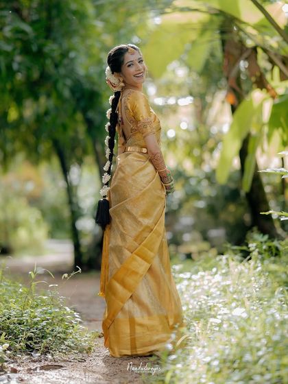 A joyful, over-the-shoulder smile from the bride. This portrait, set in a lush green pathway, feels natural and full of happiness.