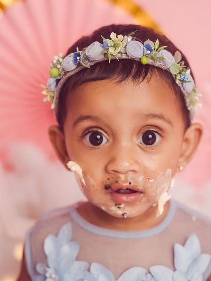 The best part of a cake smash is getting messy. This close-up shot captures the pure joy and sweetness of the moment.