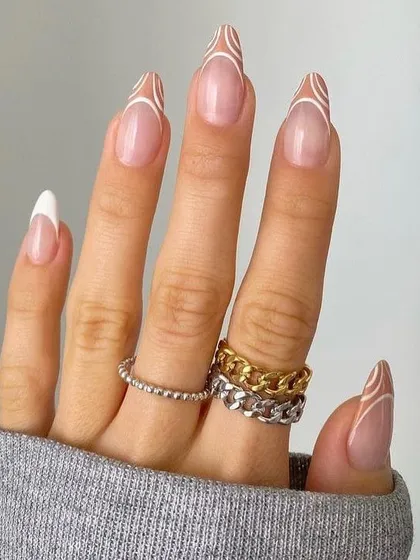 An artistic and modern French manicure with abstract white lines over a sheer nude base. This design is perfect for those who love a minimalist aesthetic with a creative touch.