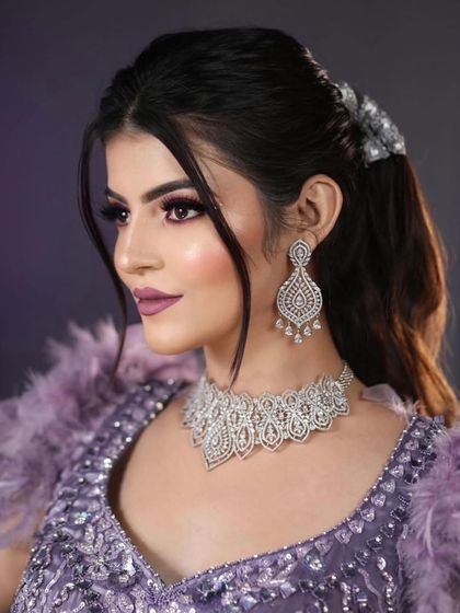 A close-up portrait of the model, highlighting the dramatic eye makeup and the flawless, sculpted base.