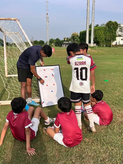 It's not just about drills, it's about strategy. Here, one of our AIFF certified coaches uses a tactical board to teach our U-10 players how to read the game, understand positioning, and make smarter decisions on the field.